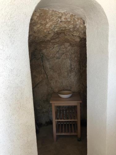 een kleine tafel in een grot met een stenen muur bij Il Terrazzo in Santo Stefano di Sessanio