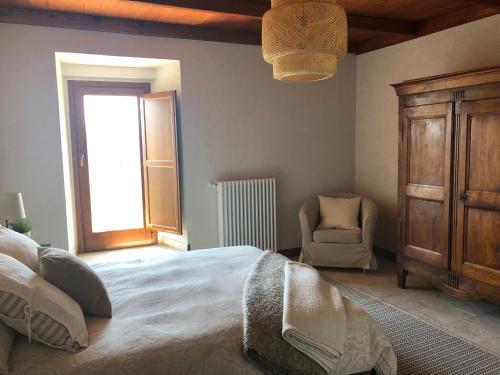 een slaapkamer met een bed, een stoel en een raam bij Il Terrazzo in Santo Stefano di Sessanio
