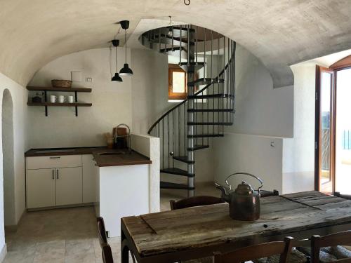 een keuken met een houten tafel en een wenteltrap bij Il Terrazzo in Santo Stefano di Sessanio