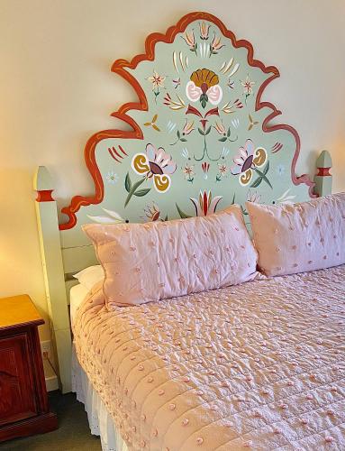a bedroom with a bed with a floral headboard at Hofsas House Hotel in Carmel
