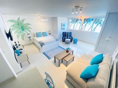 KASA Las Palmas studio apt for 2 OCEAN VIEW BEACHFRONT CONDO POOL في سان خوان: غرفة معيشة مع أريكة وسرير