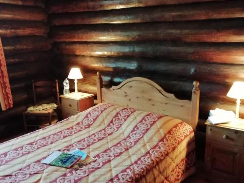 une chambre avec un lit dans une cabane en rondins dans l'établissement Chalet near Quend Beach with Pool, à Quend