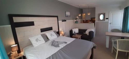 a bedroom with a large white bed and a living room at Appartement Duinzee Texel in De Koog