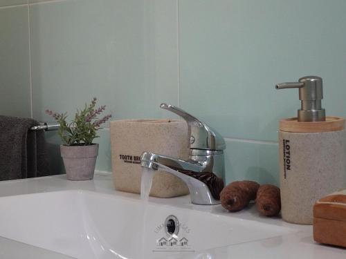 a sink with a faucet and some donuts on a counter at LIMA COTTAGES - Casa de S Tiago in Ponte de Lima