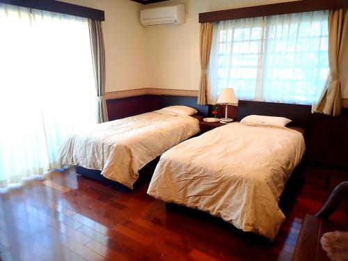 1 dormitorio con 2 camas y mesa con lámpara en Villa CocoNatu - KOHAMA - en Kohama