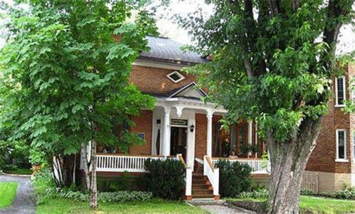 una casa de ladrillo con un banco delante de ella en Aux Années Folles, en Quebec