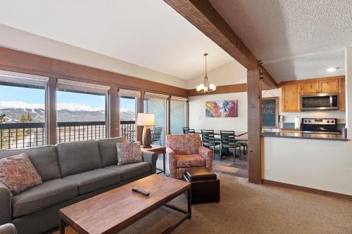 a living room with a couch and a table and a kitchen at Gold Point Resort Breckenridge by Vacatia in Breckenridge