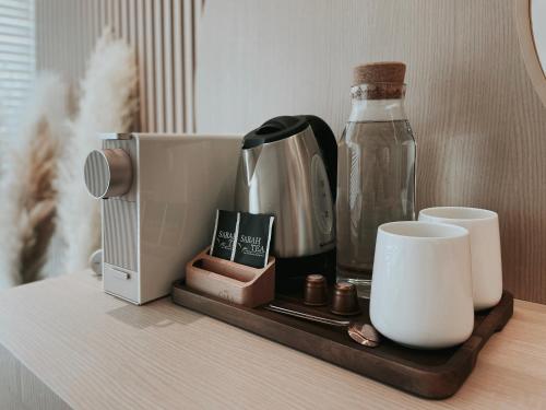 a tray with a coffee maker and a bottle on a table at The Cara Boutique Hotel in Kota Kinabalu
