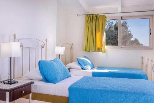 シヴォタにあるVotsaloのベッドルーム1室(青いシーツと窓付きのベッド2台付)