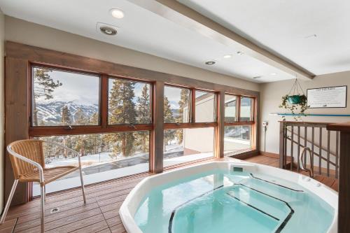 a jacuzzi tub in a room with windows at Gold Point Resort Breckenridge by Vacatia in Breckenridge