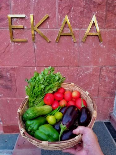 a person holding a basket of vegetables in front of a wall at Ekaa Villa near Taj Mahal in Agra