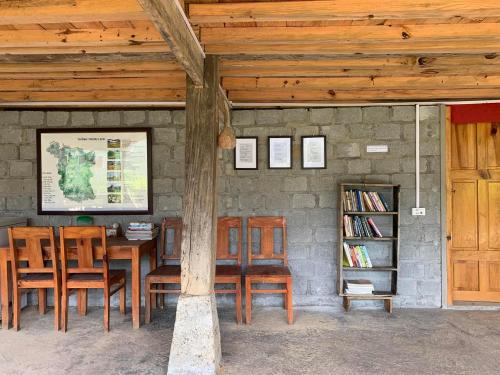 um quarto com uma mesa e cadeiras e uma estante de livros em Nậm Lỳ Retreat- Breakfast included em Ha Giang