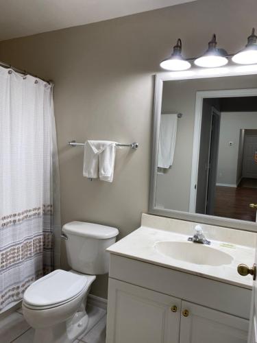 La salle de bains est pourvue de toilettes, d'un lavabo et d'un miroir. dans l'établissement Windemere on Marco Island. 4 BR waterfront home, à Marco Island