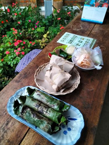 two plates of food on a wooden table at AZALEA GARDEN HOMESTAY in Pagaralam