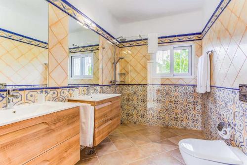 a bathroom with a tub and a sink and a toilet at Casa Janus in Carvoeiro
