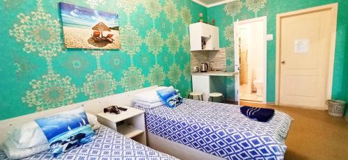 a bedroom with two beds and a green wall at Rent Rooms Barracuda in Khabarovsk