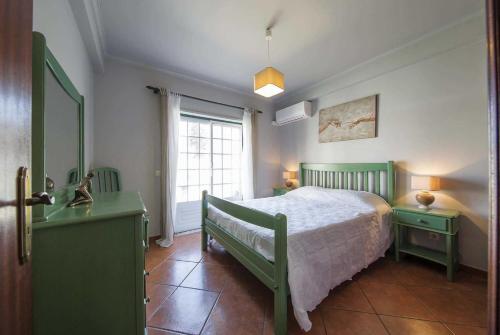 PatrovesにあるVivenda Ratoのベッドルーム(緑のベッド1台、窓付)