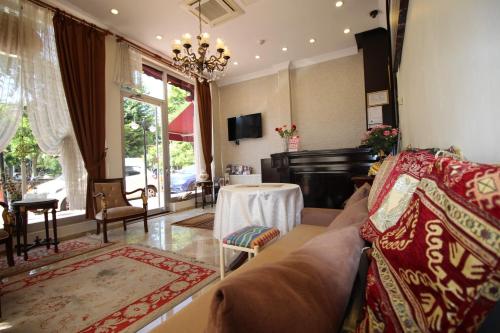 een woonkamer met een bank en een piano bij Sultans Hotel in Istanbul