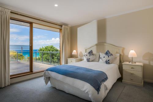 a bedroom with a bed with a view of the ocean at Baudin House in Penneshaw