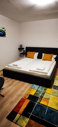 a large bed in a room with a colorful rug at Focus Lux in Miercurea-Ciuc