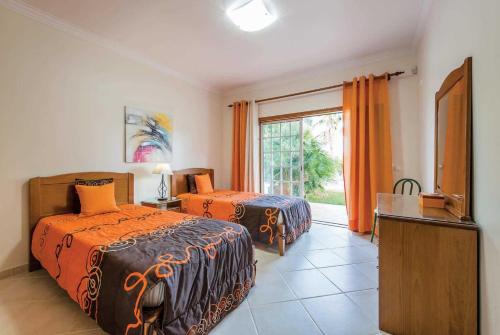 1 Schlafzimmer mit 2 Betten, einem TV und einem Fenster in der Unterkunft Los Olivos Lea in Boliqueime