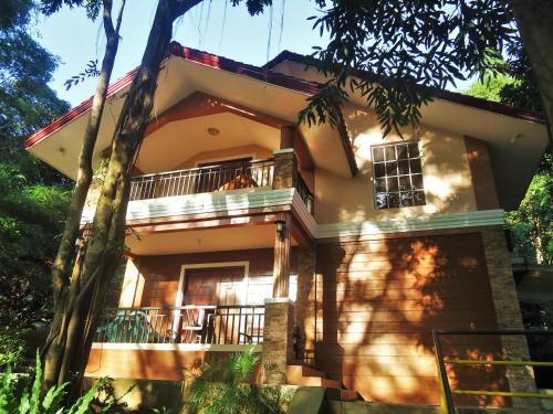 a house with a balcony and trees in front of it at Momarco Forest Cove in Tanay