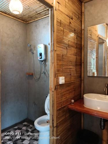 a bathroom with a sink and a toilet and a mirror at สวนเกษตรรักษ์ไผ่ Bamboo Conservation Farm in Surin