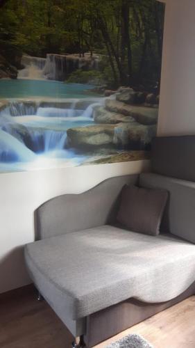 a couch in a room with a painting on the wall at Pensiunea Tarina in Şuncuiuş