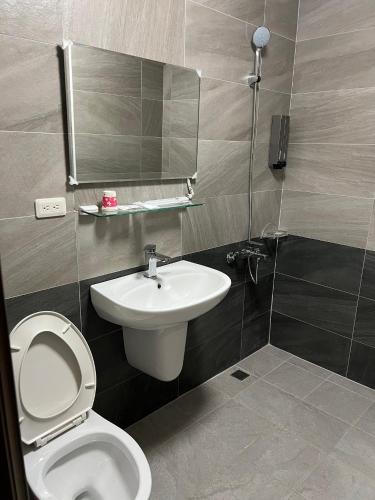 a bathroom with a toilet and a sink and a mirror at 墾丁 63民宿 in Kenting