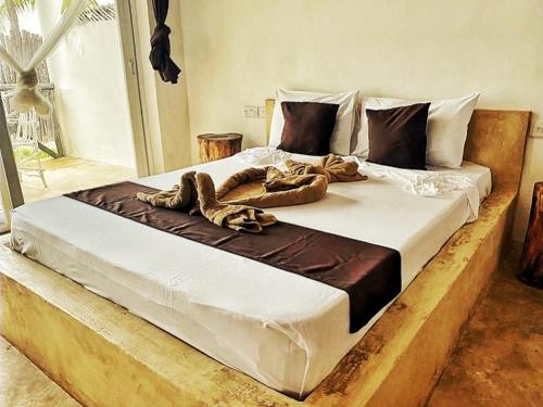a large bed with two ropes on top of it at Ayla Beach House in Kiwengwa