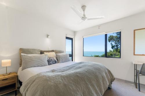 a bedroom with a bed and a large window at Ocean Spa Views in Nelson