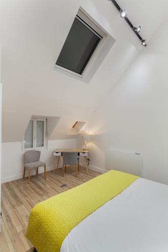 una camera con letto giallo e scrivania di Suite Appart Place Versepuy a Chantilly