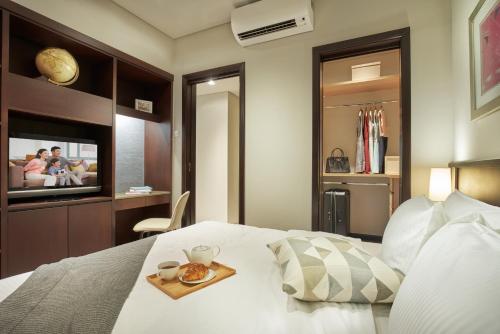 a bedroom with a bed with a tray of food on it at Somerset Bencoolen Singapore in Singapore