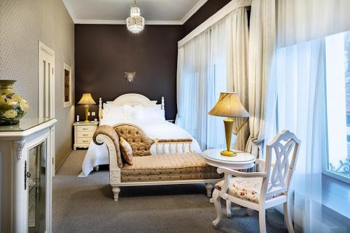 a bedroom with a bed and a table and a chair at Residentsiya (Izvolte) Hotel in Rostov on Don