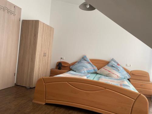 a bedroom with a wooden bed with pillows on it at Fam M&H Schönes Zimmer Vermieten in Wangen Im Allgäu in Wangen im Allgäu