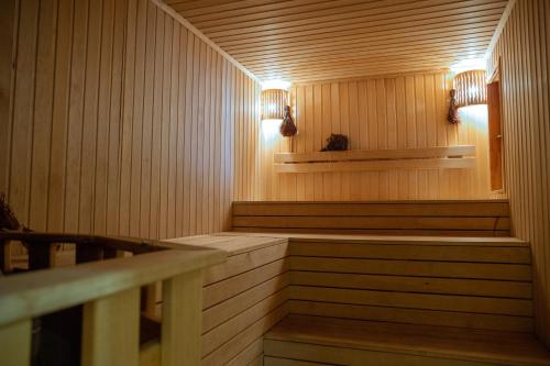 a sauna with wooden paneling and lights on the wall at Айбарка in Uznezya