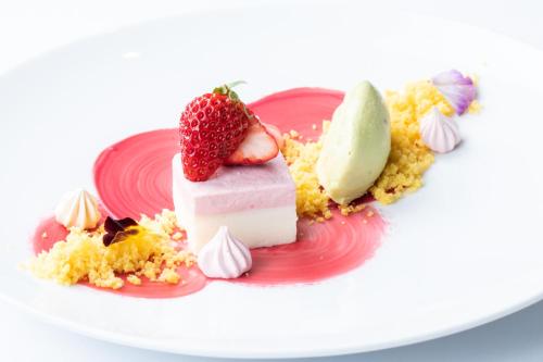 a pink plate with a dessert with a strawberry on it at Matsumoto Hotel Kagetsu in Matsumoto