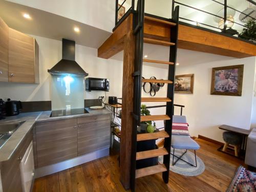 een keuken met een hoogslaper en een trap in een keuken bij Duplex cosy au cœur de Barcelonnette in Barcelonnette