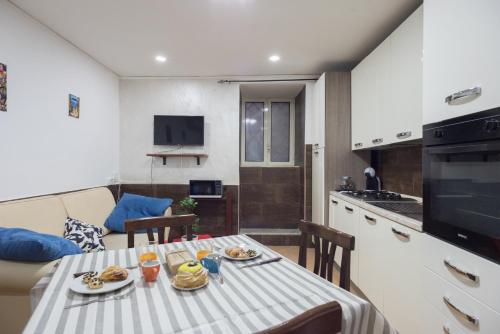 une petite cuisine avec une table et une salle à manger dans l'établissement (Room in Naples) Casetta Decumani, à Naples