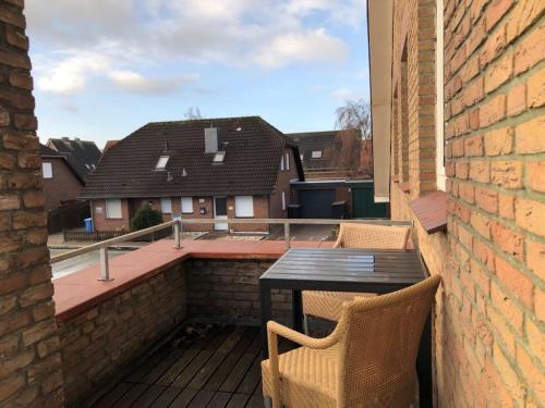 a patio with a table and chairs on a balcony at Ferienwohnungen Strandglück in Norddeich