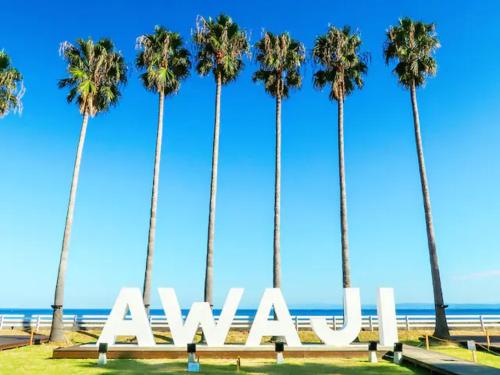 a group of palm trees with the ocean in the background at Awaji Seaside Resort in Iwaya 3000 in Awaji
