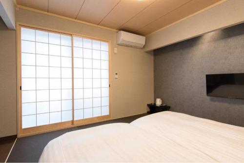 - une chambre avec un lit et une grande fenêtre dans l'établissement Karasuma Rokujo Hotel / Vacation STAY 2829, à Kyoto