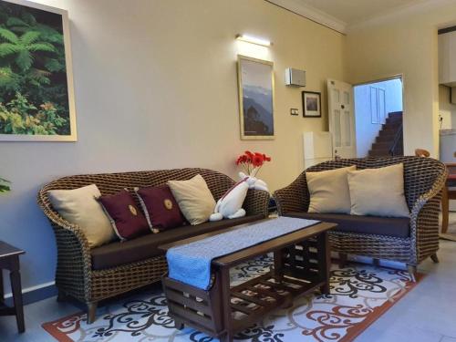 Sala de estar con 2 sofás y mesa de centro en Gerard's Place Nature Heaven Apartment en Tanah Rata