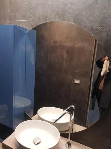 MASSARO APARTMENTS VIA CAVORSO CHIETI Abruzzo في كييتي: شخص يلتقط صورة للحمام مع مرآة