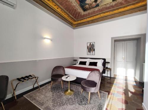 - une chambre avec un lit, deux chaises et une table dans l'établissement Visconti Suites by FNA Hospitality Roma, à Rome