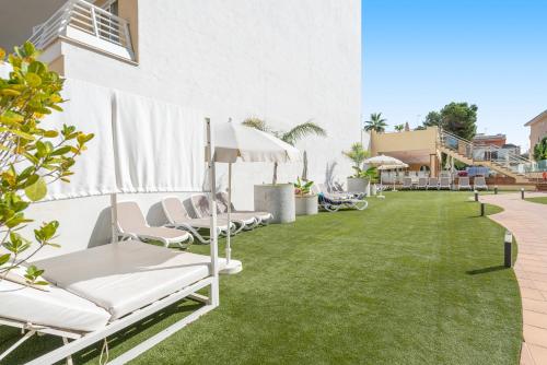 a patio with lawn chairs and umbrellas at O7 Nordeste Playa in Can Picafort