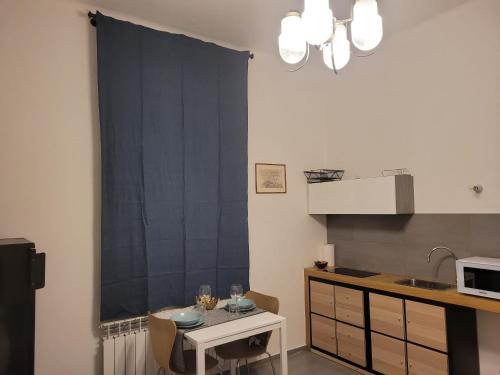 a kitchen with a black window curtain and a table at Dormi Tranquillo in Bologna