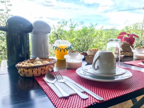 a table with a red napkin and utensils on it at Sítio Colibri - Serra da Mantiqueira in Brazópolis