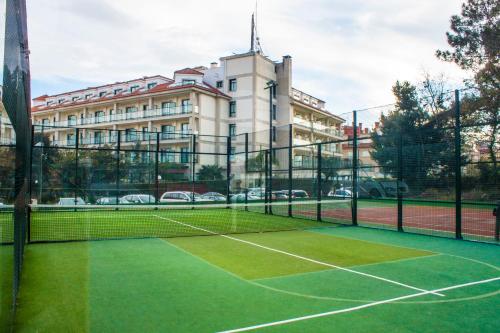 una pista de tenis frente a un edificio en Hotel Carlos I Silgar, en Sanxenxo