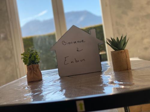 a sign on a table with some plants on it at Embrun - Appartement 4/6 personnes avec extérieurs in Embrun